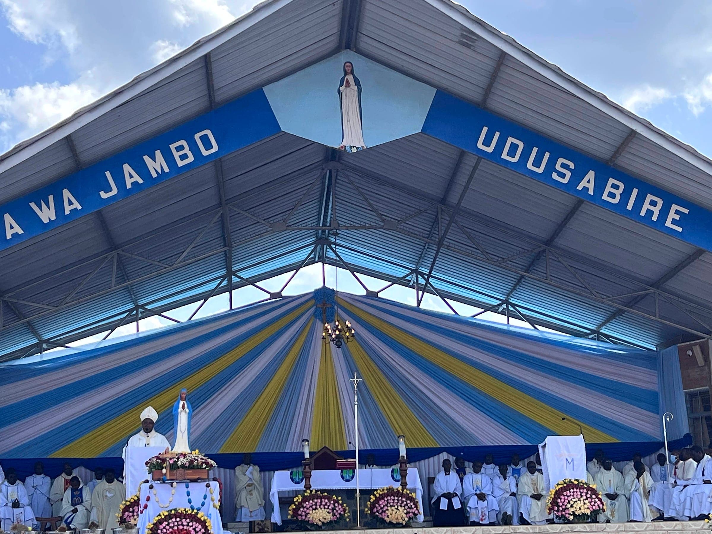 The outdoor altar at Kibeho under a banner reading Nyina wa Jambo, Udusabire